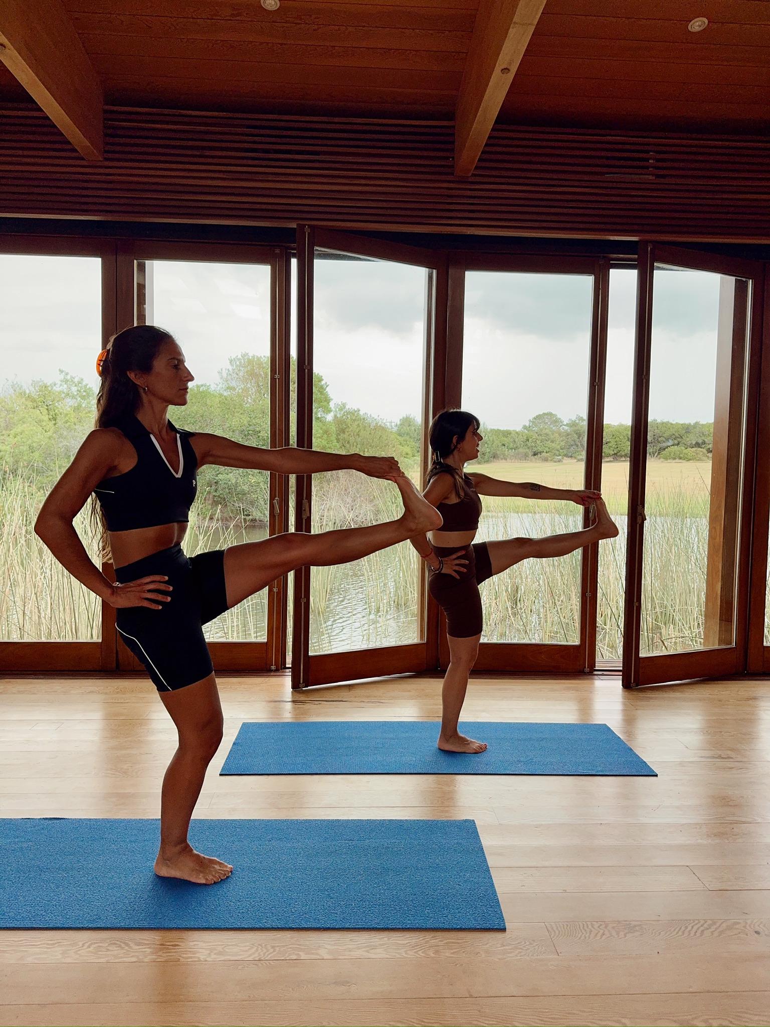 Dos mujeres en una postura de yoga de frente en Las Musas