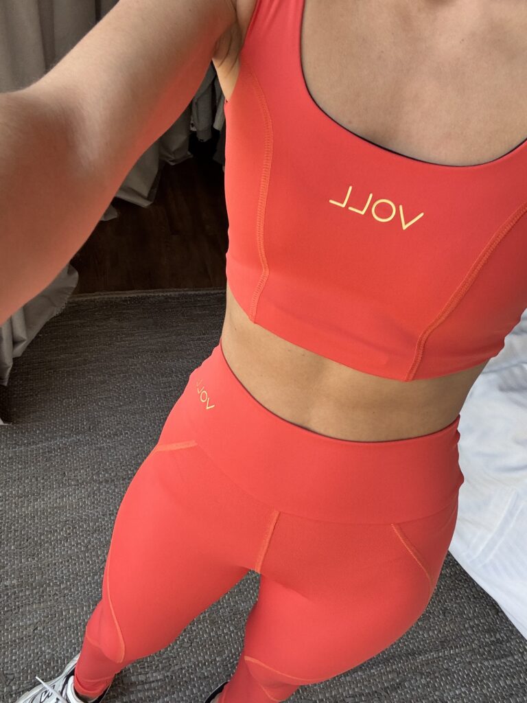 Mujer usando conjunto aerobic en color coral para pilates y yoga