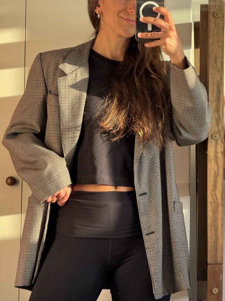 mujer usando cropped modal en color negro, manga 3/4 con blazer