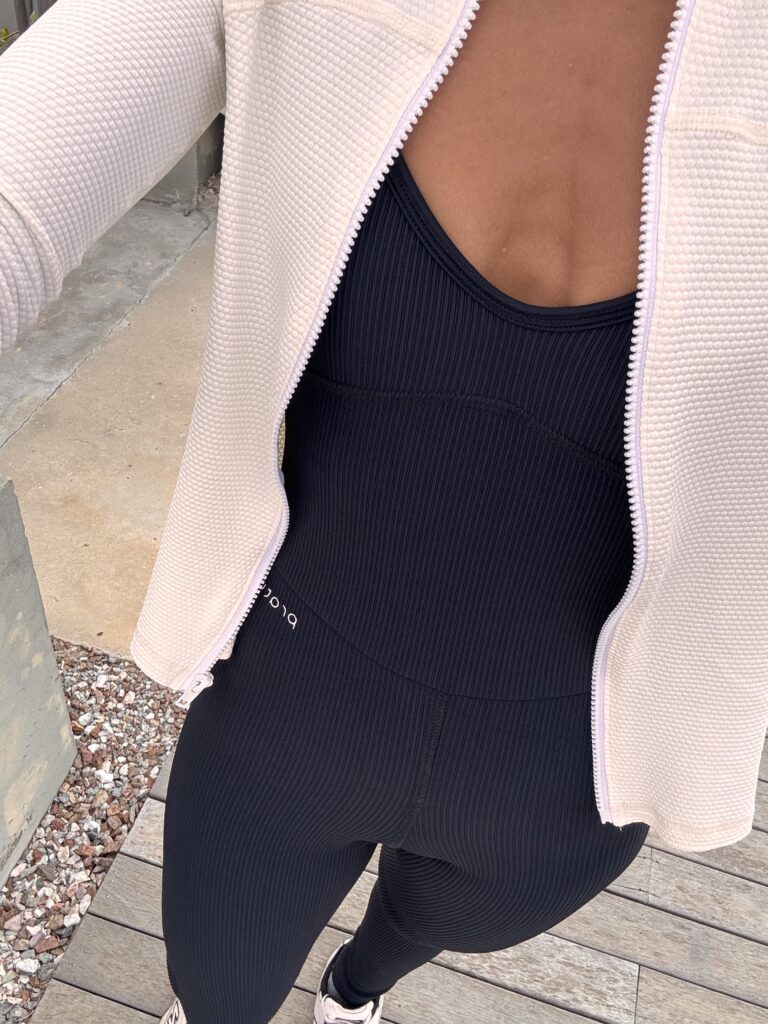 mujer vistiendo mono deportivo y campera pratyque